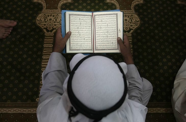 A-man-reads-the-Quran-at-004